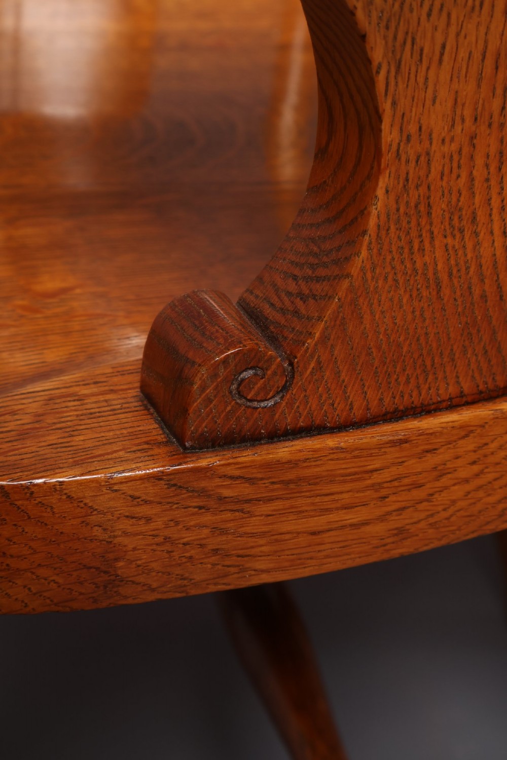 An antique Victorian golden oak desk chair featuring a curved spindle back, curved armrests, a contoured seat, and cabriole front legs. View XI