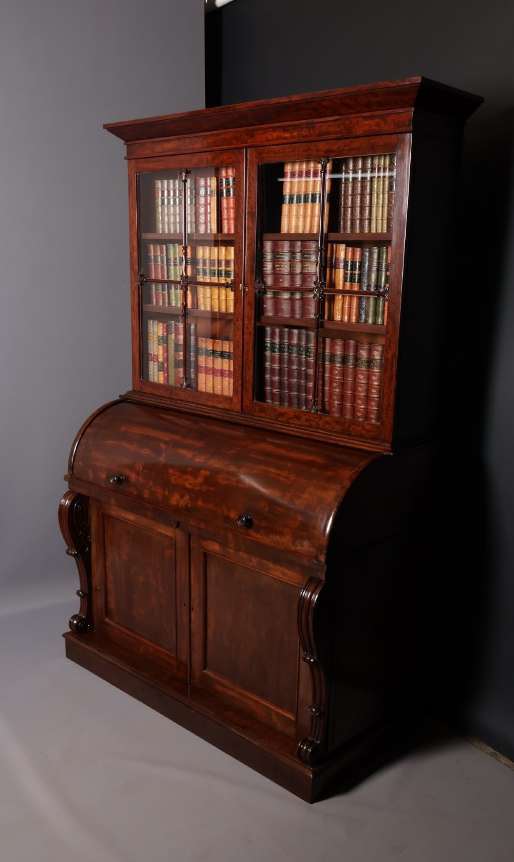 A William IV mahogany cylinder bureau bookcase featuring a two-door glazed upper cabinet, a rounded cylinder writing section, and lower cabinet doors. View II