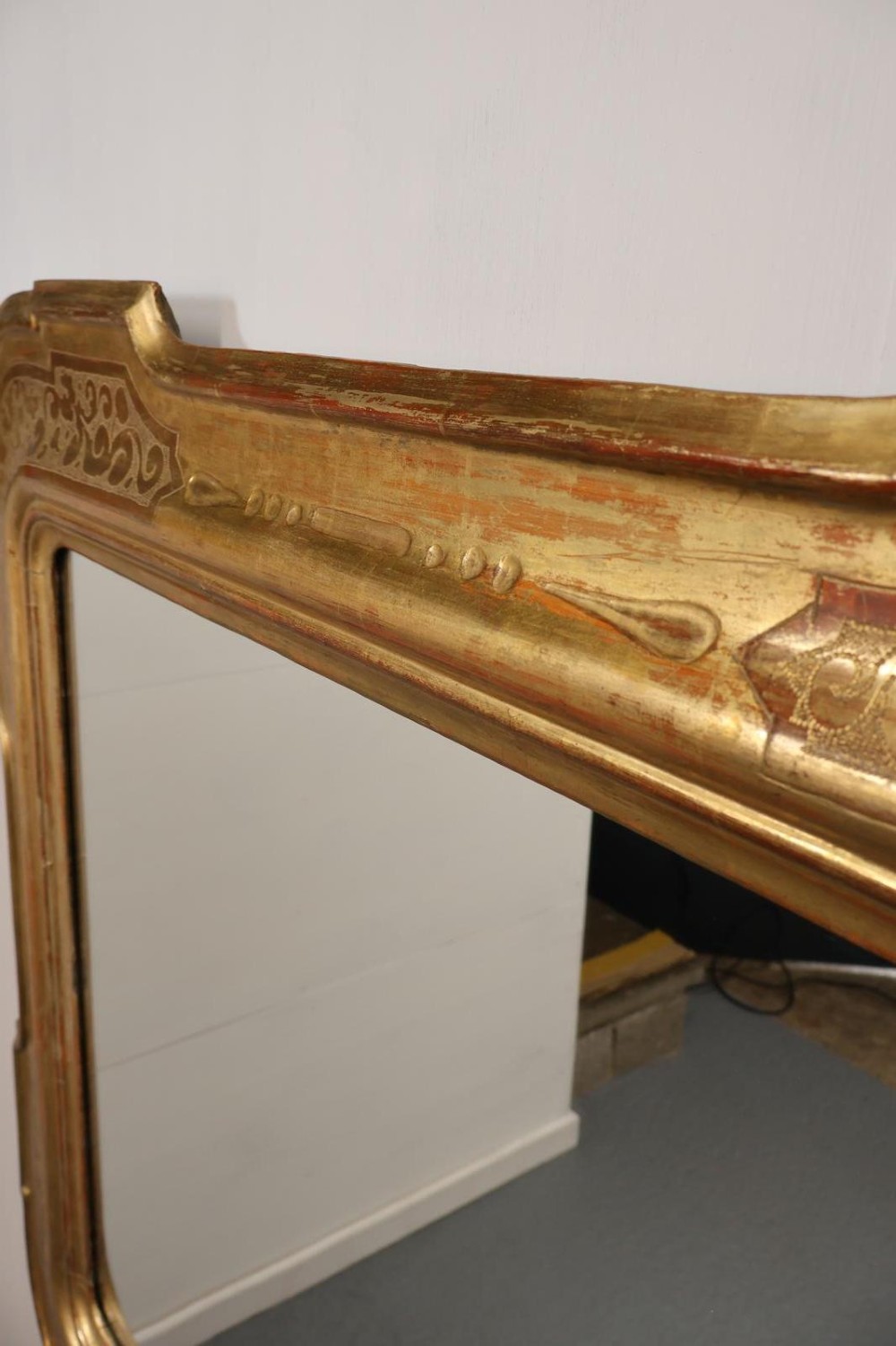 A rectangular 19th-century wall mirror featuring an ornate gold leaf giltwood frame with notched corners and incised scrollwork patterns. View VII