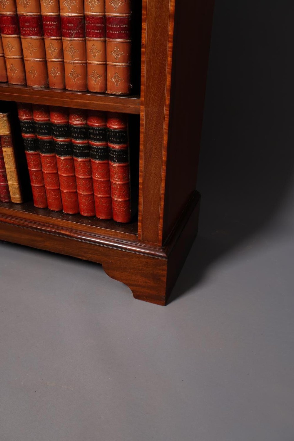 An Edwardian open-front mahogany bookcase featuring four wide shelves and decorative inlaid borders along the frame. View IV