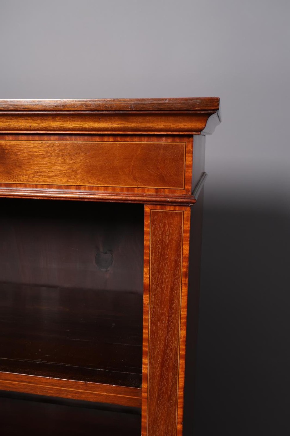 An Edwardian open-front mahogany bookcase featuring four wide shelves and decorative inlaid borders along the frame. View VI