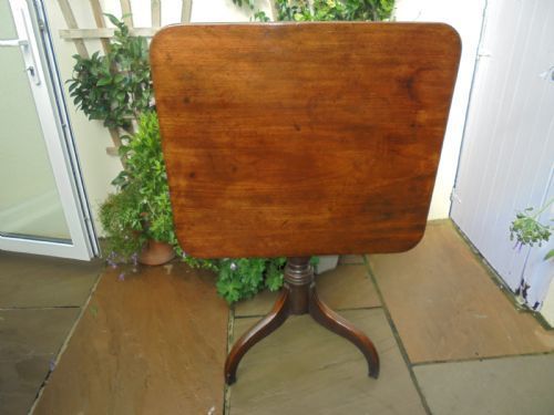fig 1. An antique Regency mahogany tripod table with a square tilt-top, turned central pedestal, and three down-swept legs.