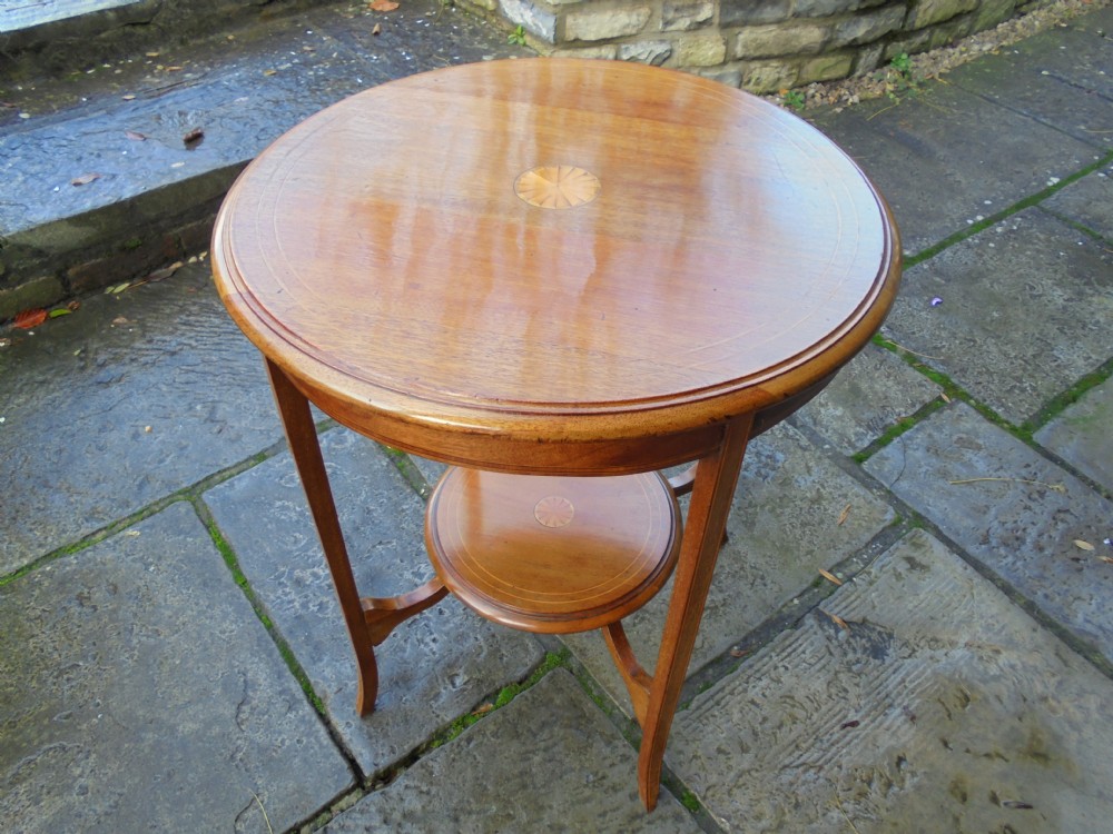 Circular mahogany two tier occasional table with sunburst inlay on each level.