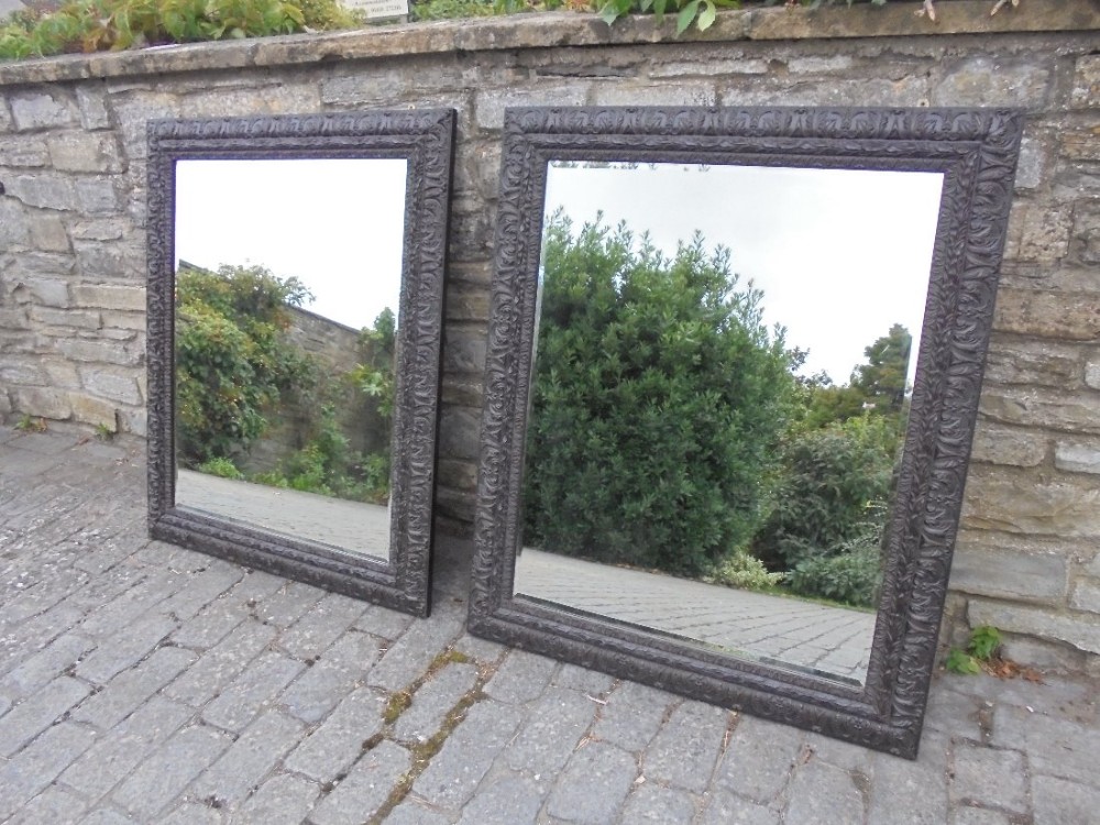 An impressive pair of very large bevelled glass hanging wall mirrors.