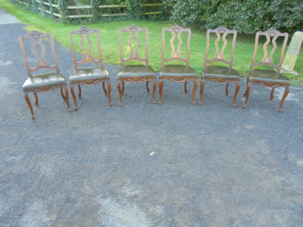 Set of six French carved oak dining chairs with leather seats and high back