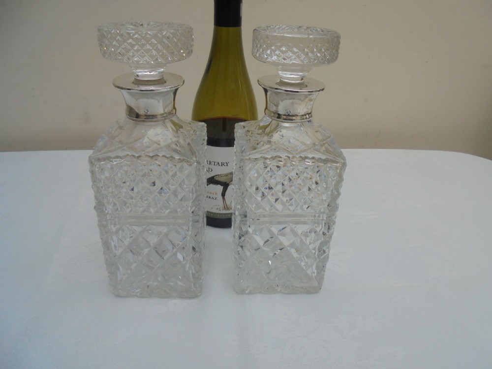 Pair of cut glass, silver top square decanters. View II