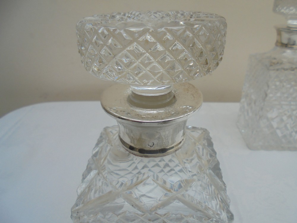Pair of cut glass, silver top square decanters. View III