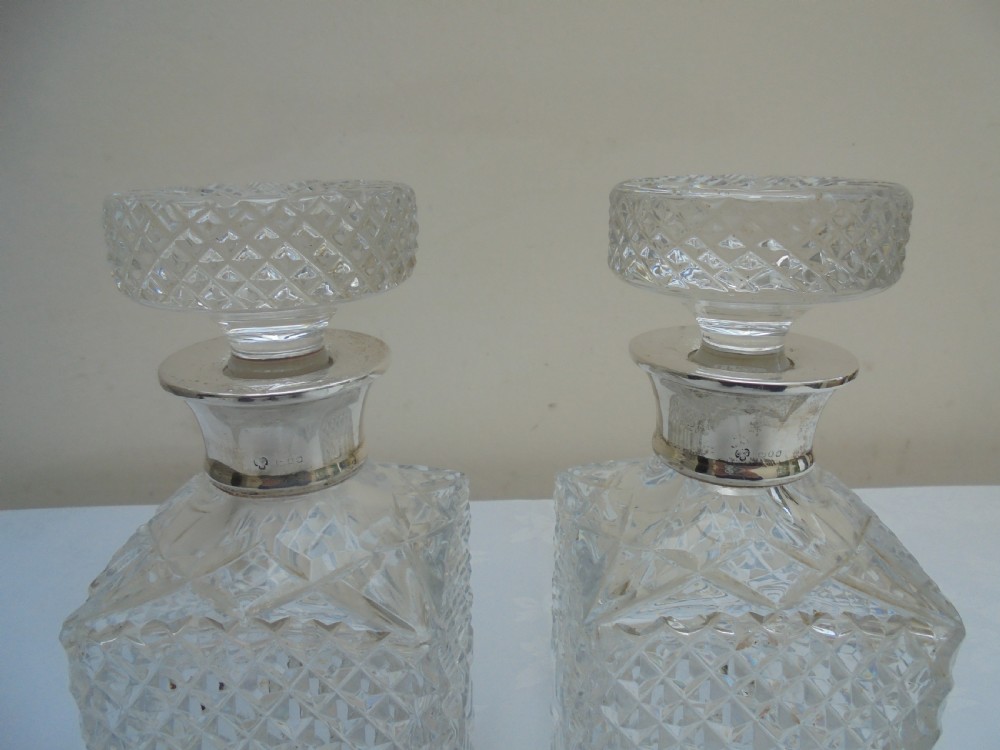Pair of cut glass, silver top square decanters. View V