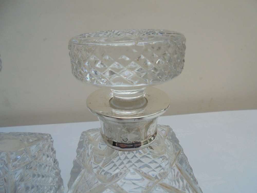 Pair of cut glass, silver top square decanters. View VII