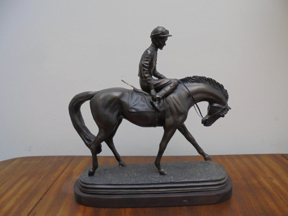Bronzed jockey on racehorse
