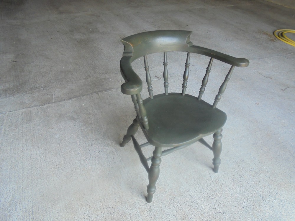 A low-backed wooden captains chair painted in dark green, featuring turned spindles, a curved armrest, and a shaped seat. View IV