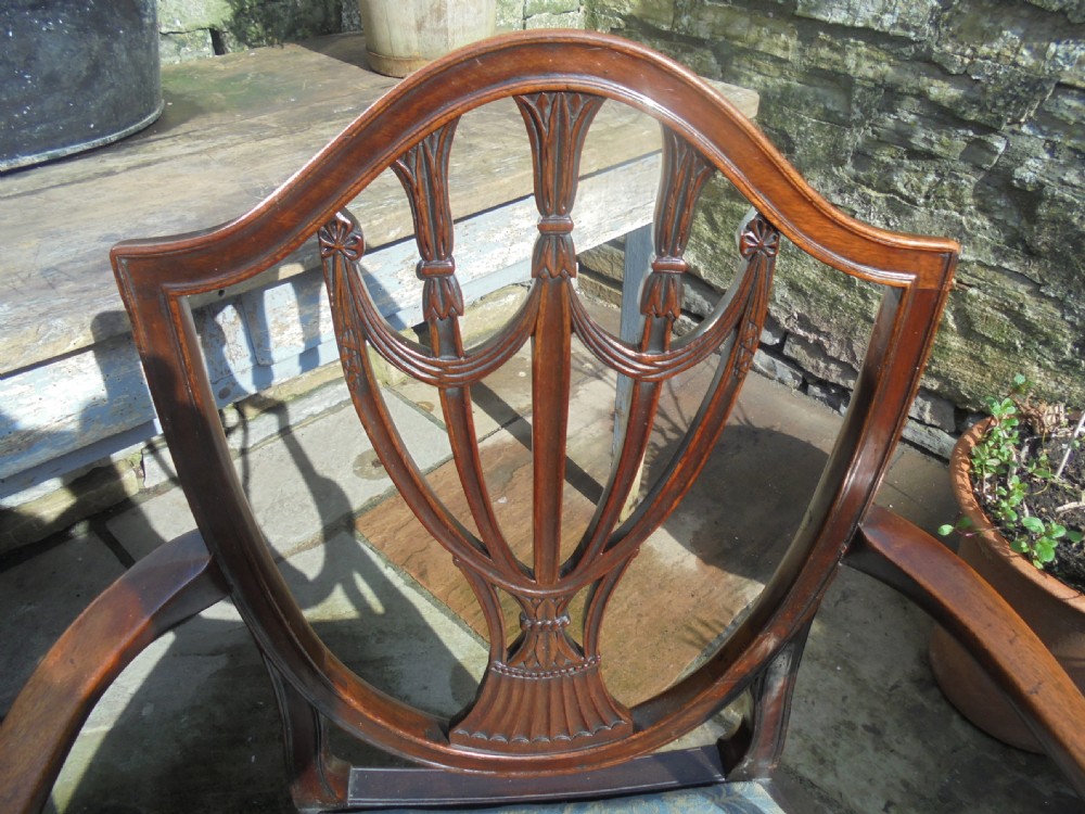 An 18th-century George III open armchair crafted from dark mahogany with a carved shield back and light blue damask seat. View III