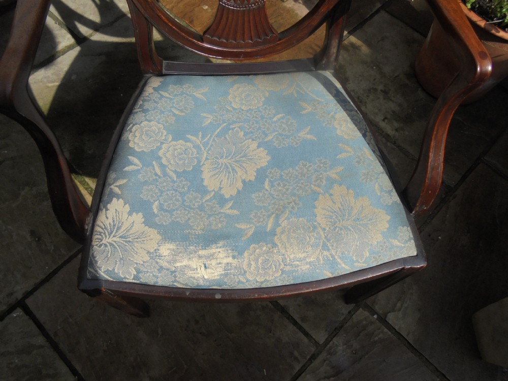 An 18th-century George III open armchair crafted from dark mahogany with a carved shield back and light blue damask seat. View IV