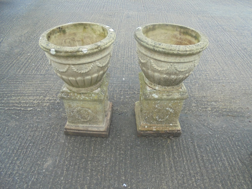 Pair of weathered  sandstone garden urns on stands  View II