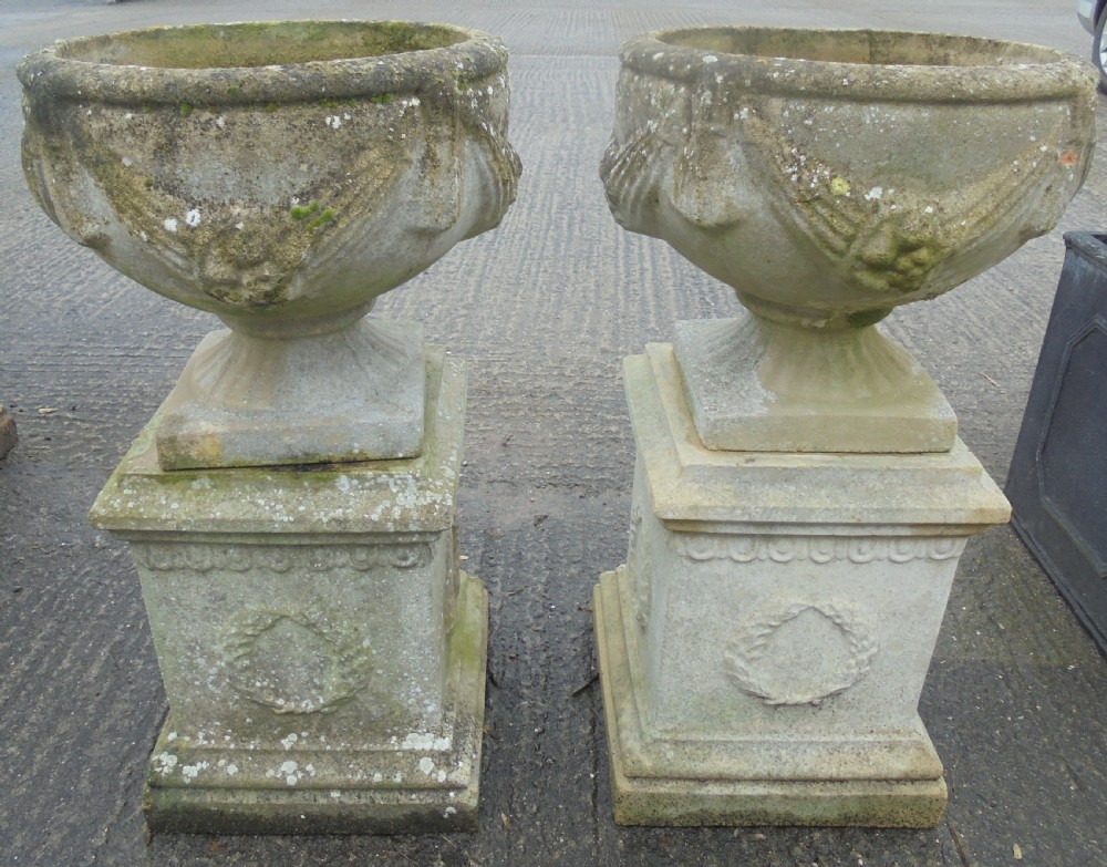 Pair of weathered sandstone garden urns on stands View III