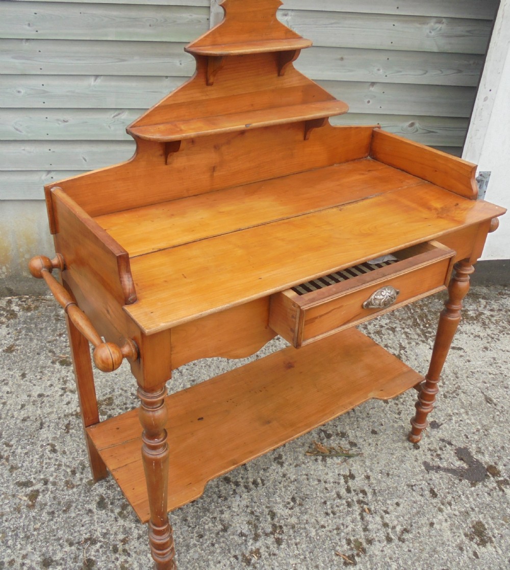 A 19th-century French cherry wood dressing table with two tiered upper shelves, turned legs, a single drawer, and an open lower shelf. View II