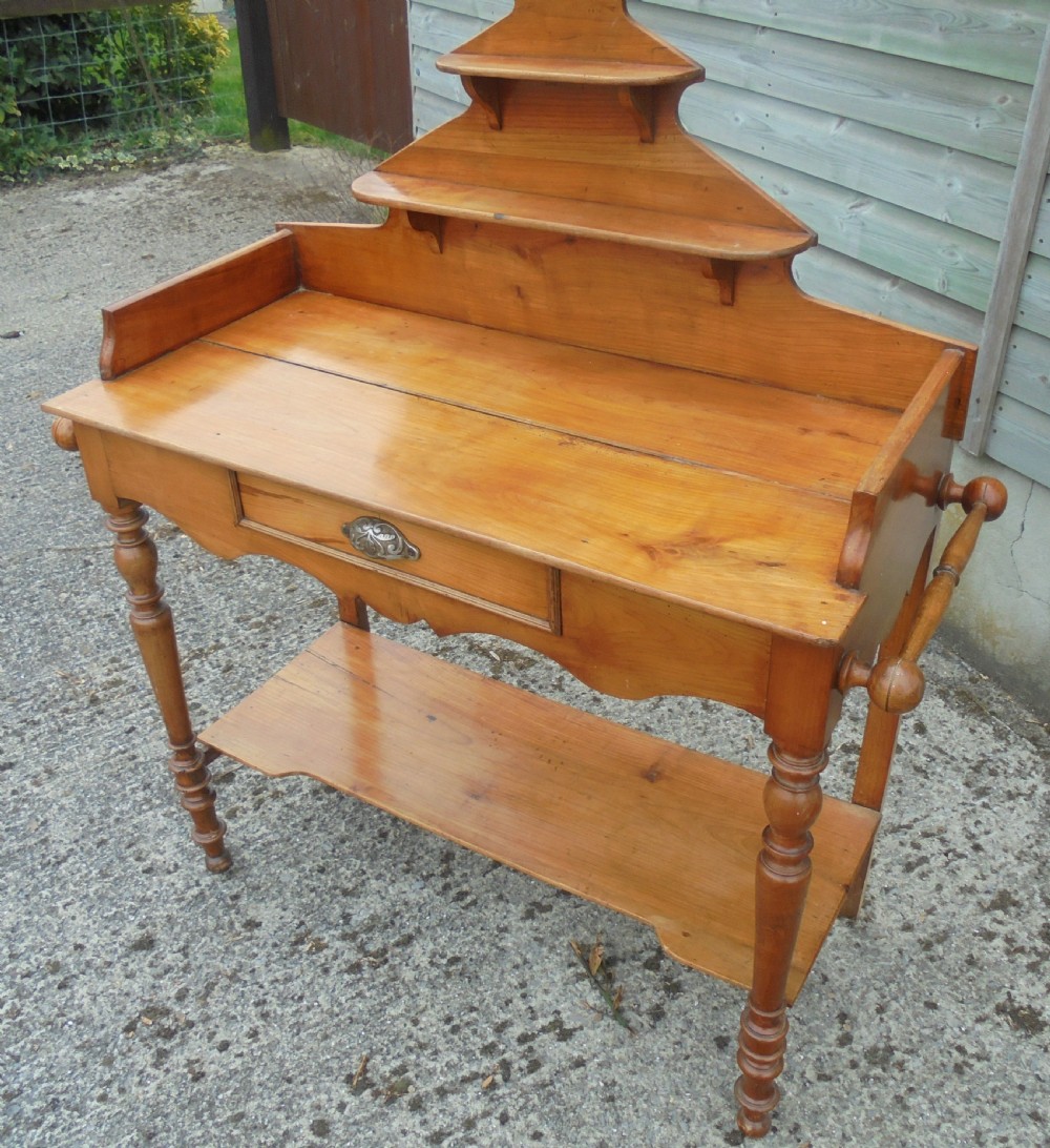A 19th-century French cherry wood dressing table with two tiered upper shelves, turned legs, a single drawer, and an open lower shelf. View III