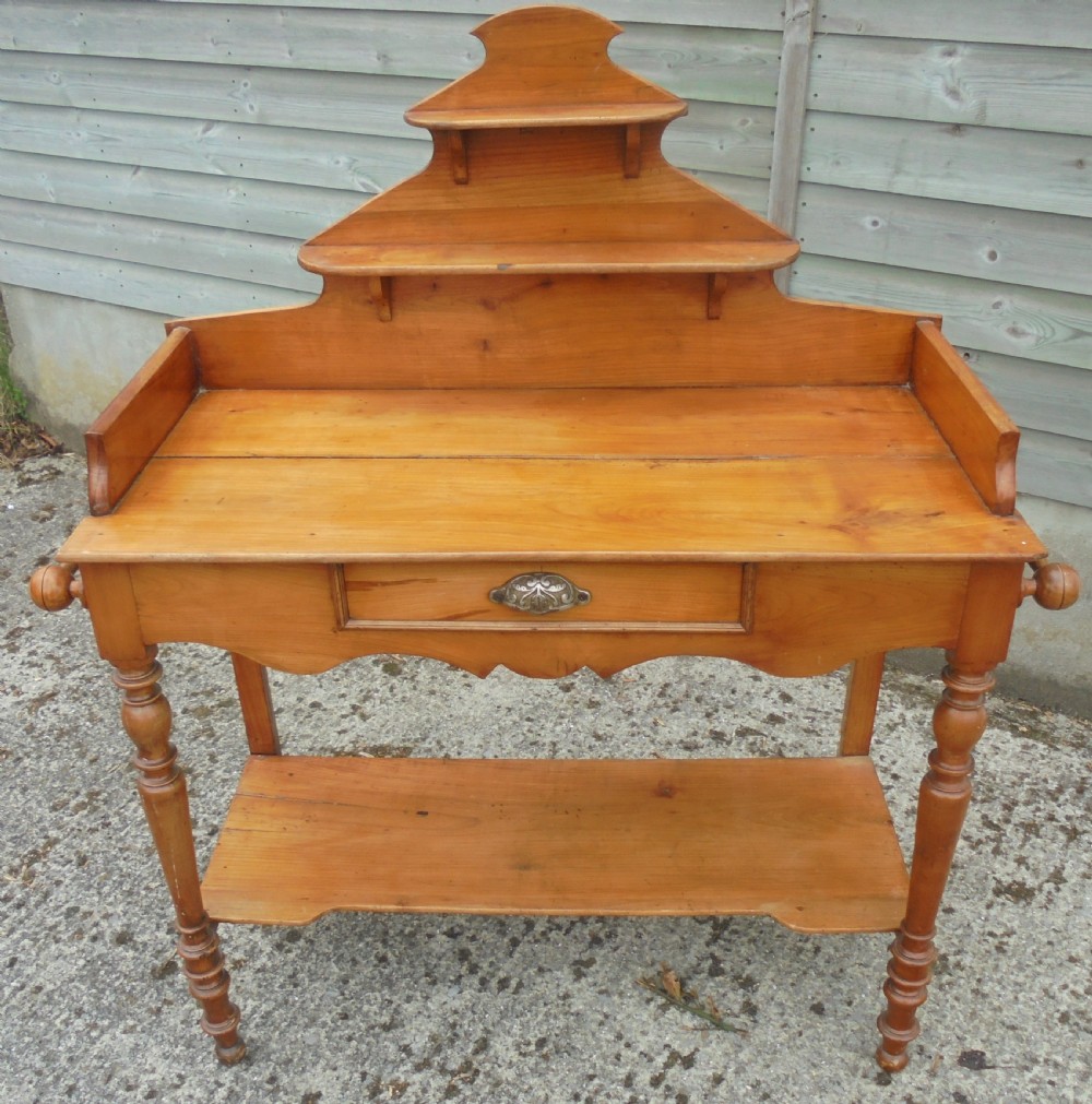 A 19th-century French cherry wood dressing table with two tiered upper shelves, turned legs, a single drawer, and an open lower shelf. View V