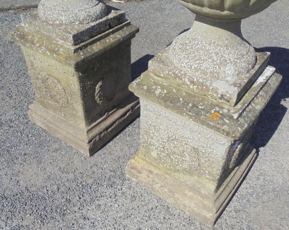 Pair of weathered sandstone garden urns on stands View III