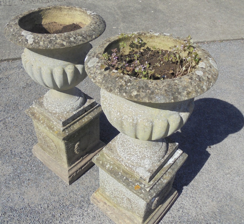 Pair of weathered sandstone garden urns on stands View IV