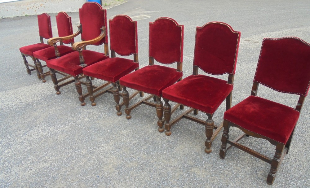 A set of seven late Victorian oak dining chairs upholstered in deep crimson velvet with brass studding, comprising six side chairs and one carver armchair. View II