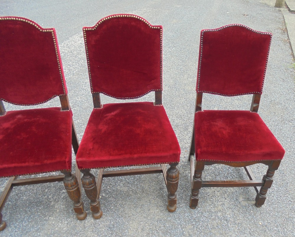 A set of seven late Victorian oak dining chairs upholstered in deep crimson velvet with brass studding, comprising six side chairs and one carver armchair. View III