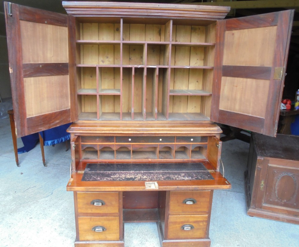 A Victorian mahogany post masters desk featuring a two-door upper cabinet above a central wide drawer and twin pedestal drawers with metal cup handles. View VI