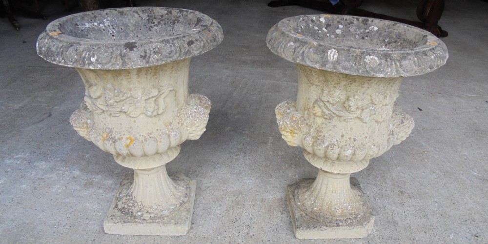 Pair well weathered stone garden urns
