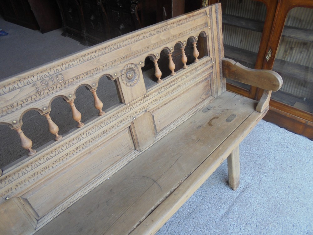 A natural light timber French country bench featuring a carved backrest with small turned spindles and panelled sections. View II