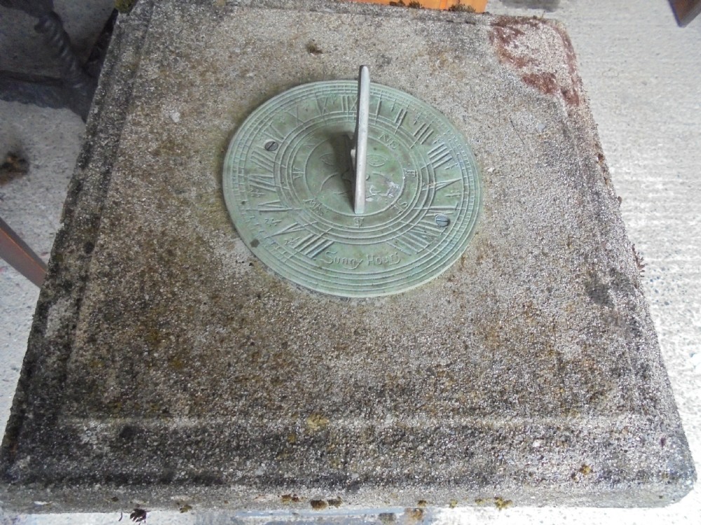 Sun dial on well weathered stand  View II