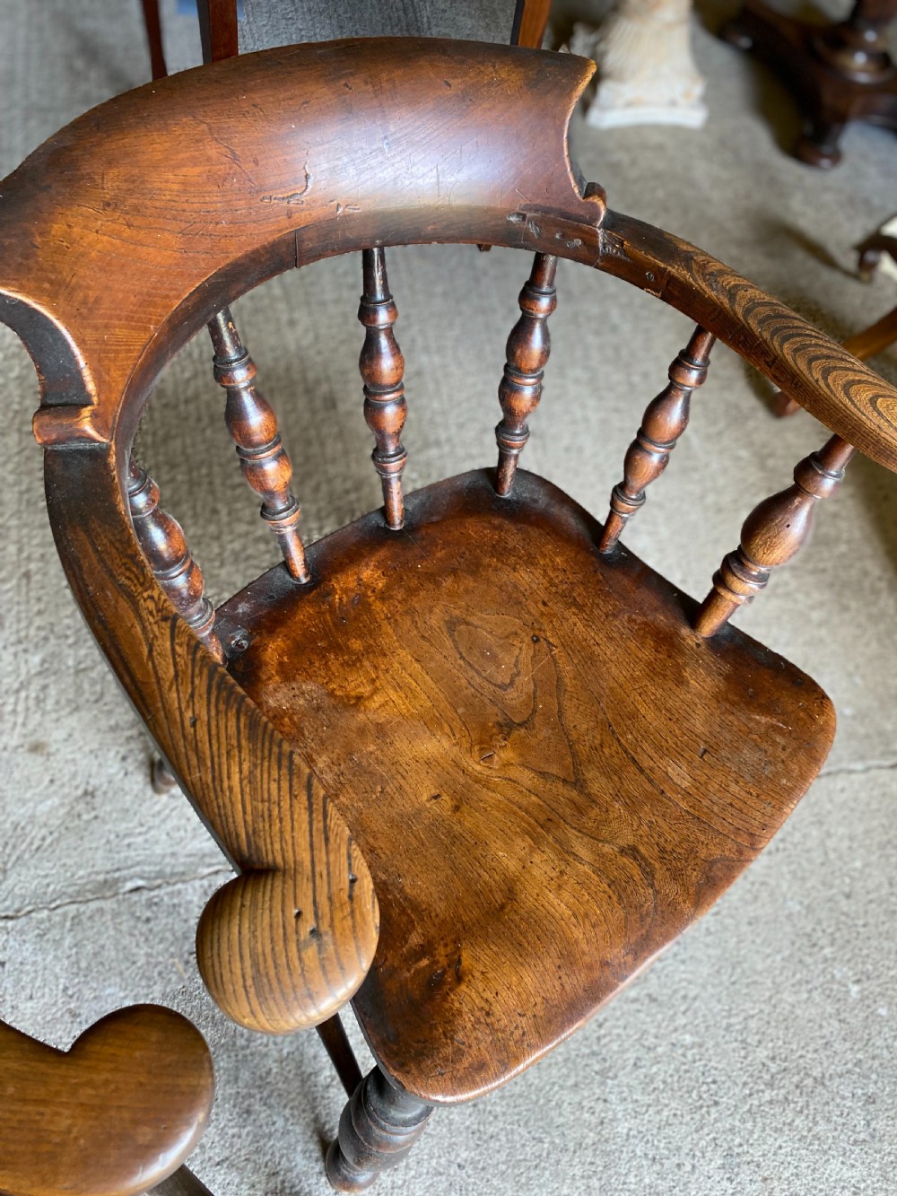 A near pair of 19th-century ash and elm smokers Captain chairs with curved crest rails, turned spindles, saddle seats, and turned legs. View II