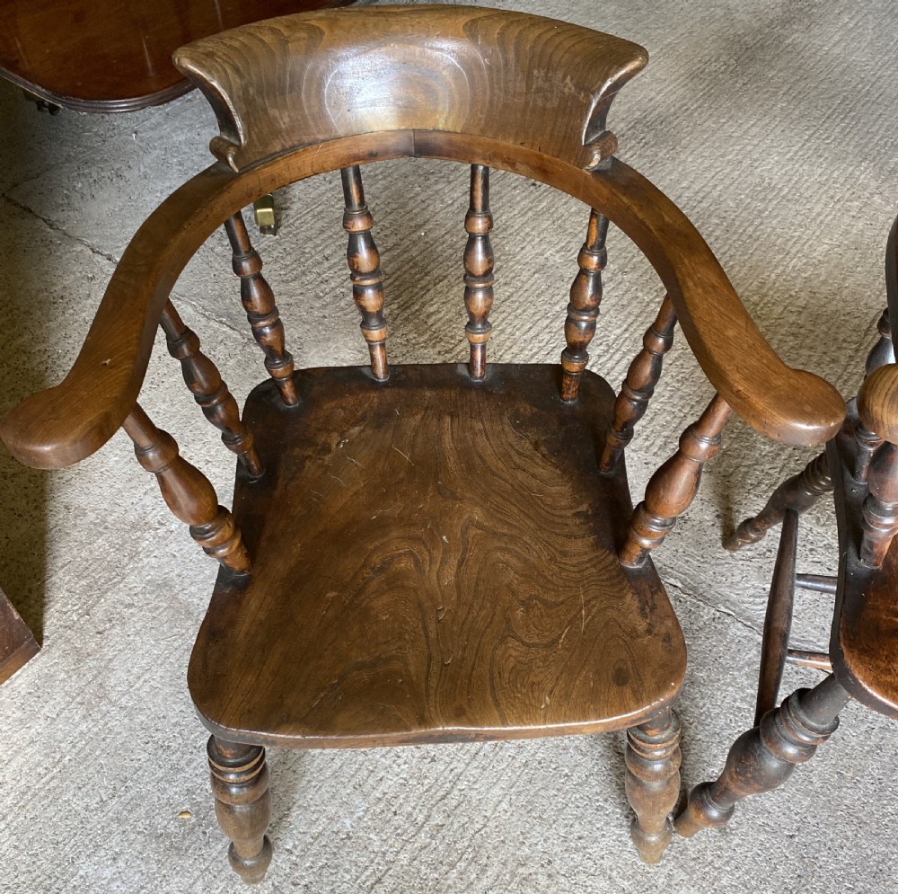 A near pair of 19th-century ash and elm smokers Captain chairs with curved crest rails, turned spindles, saddle seats, and turned legs. View III