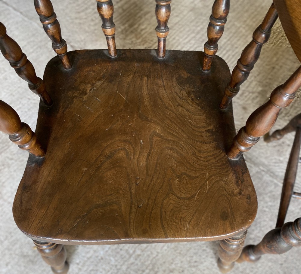 A near pair of 19th-century ash and elm smokers Captain chairs with curved crest rails, turned spindles, saddle seats, and turned legs. View VI