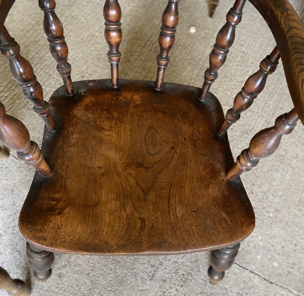 A near pair of 19th-century ash and elm smokers Captain chairs with curved crest rails, turned spindles, saddle seats, and turned legs. View VII