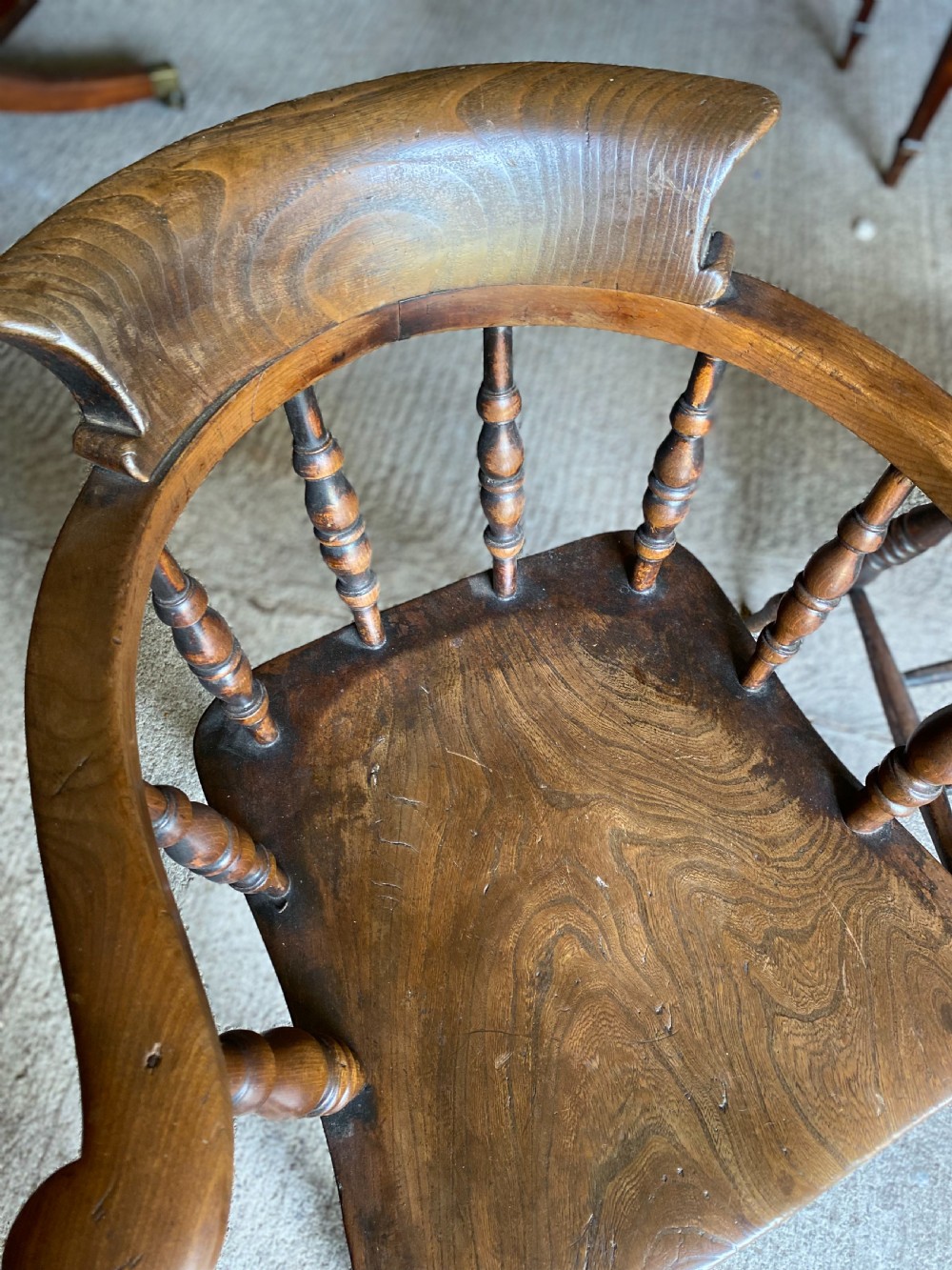 A near pair of 19th-century ash and elm smokers Captain chairs with curved crest rails, turned spindles, saddle seats, and turned legs. View VIII