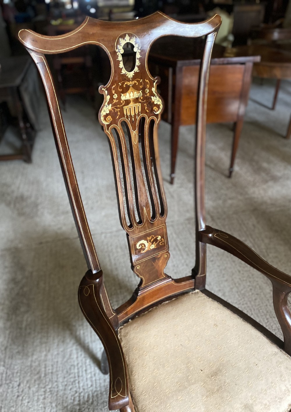 A high-back mahogany armchair featuring detailed marquetry inlay on the splat and arms with an upholstered seat. View V