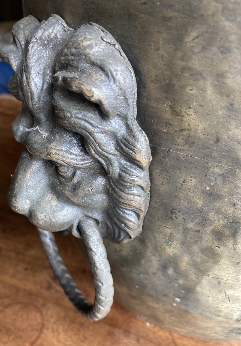 A deep bronzed brass log bucket decorated with a relief depiction of a sailing ship, supported by claw feet and featuring lion mask side handles. View II