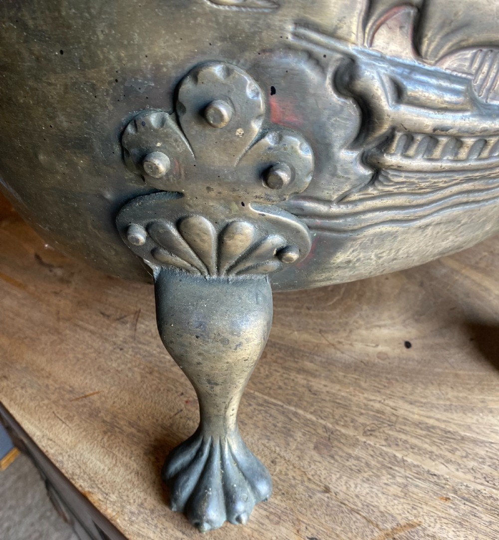 A deep bronzed brass log bucket decorated with a relief depiction of a sailing ship, supported by claw feet and featuring lion mask side handles. View III