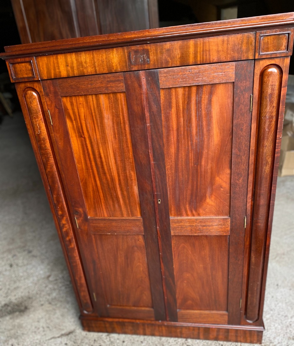 A nineteenth-century mahogany linen press cupboard featuring two panelled doors, recessed side panels, and a moulded top cornice. View III