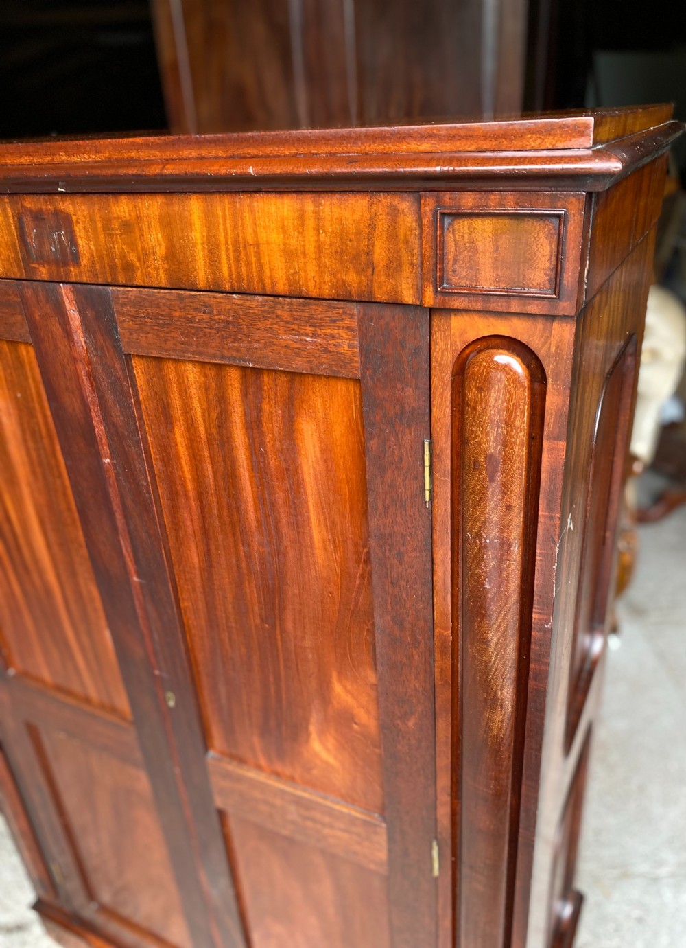 A nineteenth-century mahogany linen press cupboard featuring two panelled doors, recessed side panels, and a moulded top cornice. View V