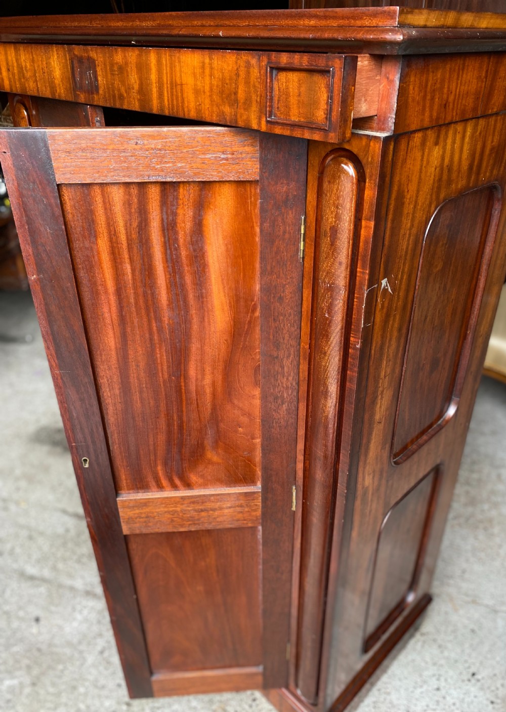 A nineteenth-century mahogany linen press cupboard featuring two panelled doors, recessed side panels, and a moulded top cornice. View IX