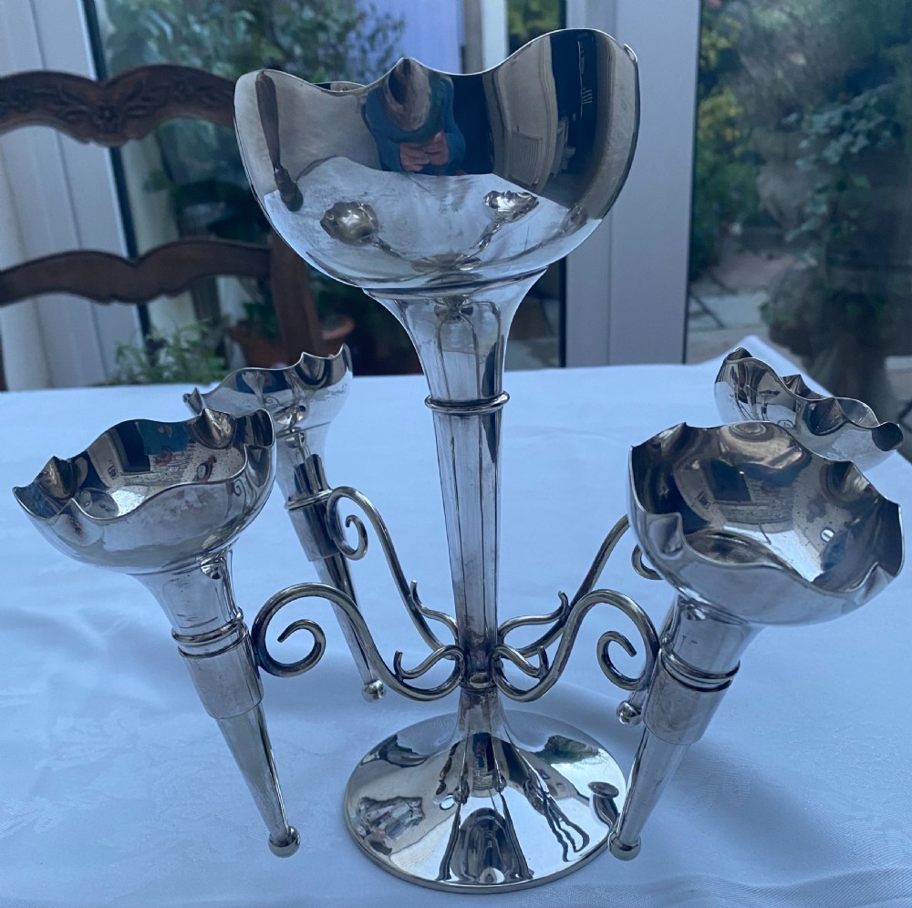 A silver-plated five-trumpet table epergne featuring a central tall trumpet vase surrounded by four smaller branching fluted vases on scroll arms. View IV