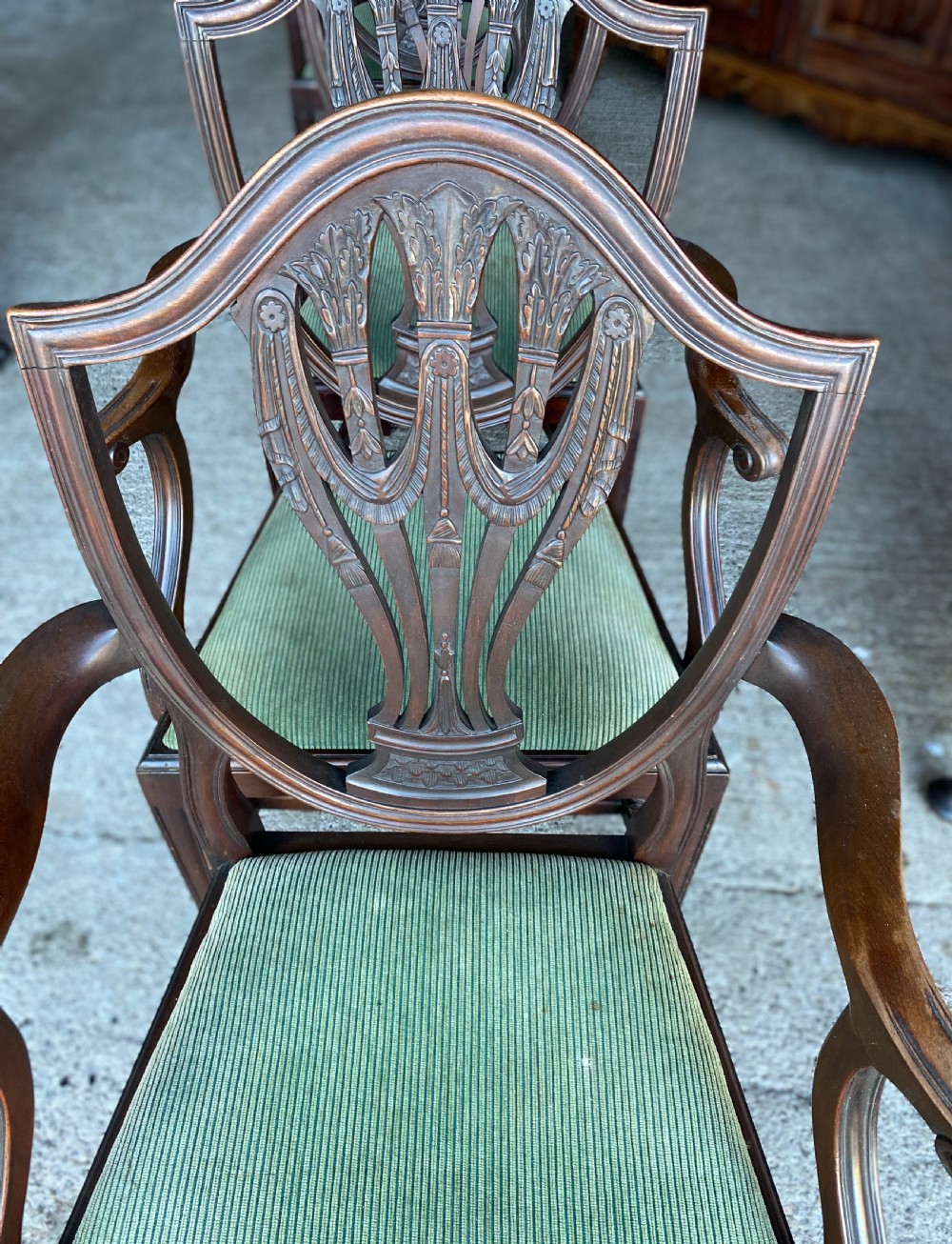 A set of antique mahogany Hepplewhite dining chairs featuring carved shield-shaped backs and green fabric upholstered seats. View III