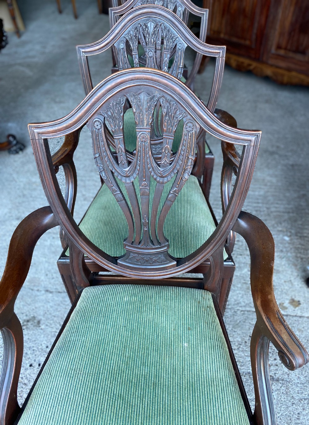 A set of antique mahogany Hepplewhite dining chairs featuring carved shield-shaped backs and green fabric upholstered seats. View IV