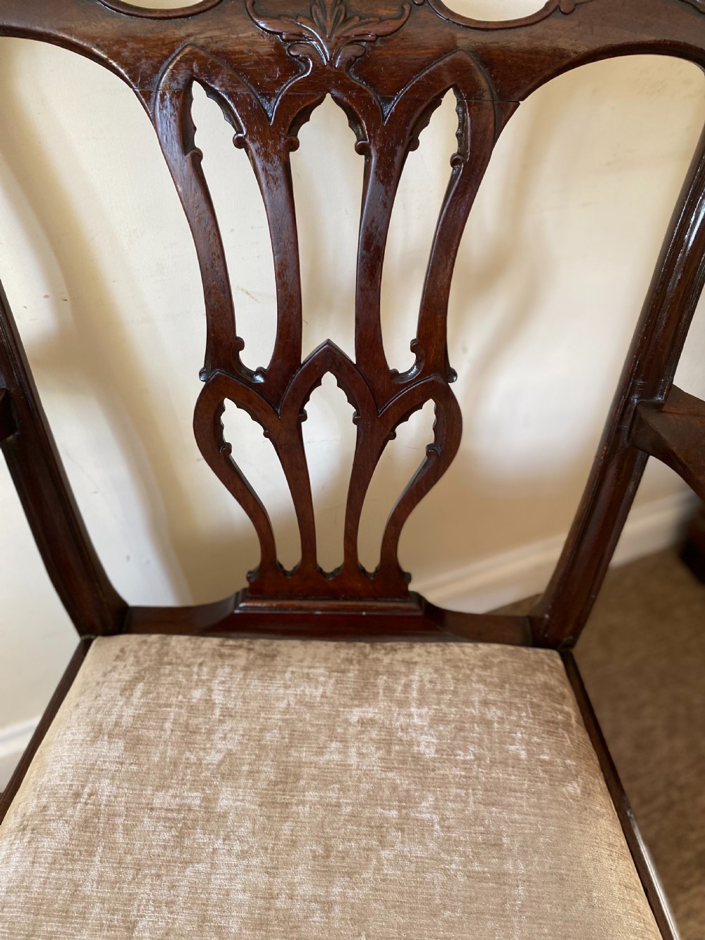 An 18th-century Chippendale mahogany armchair with a pierced carved back splat, swept arms, and a beige upholstered drop-in seat pad. View II