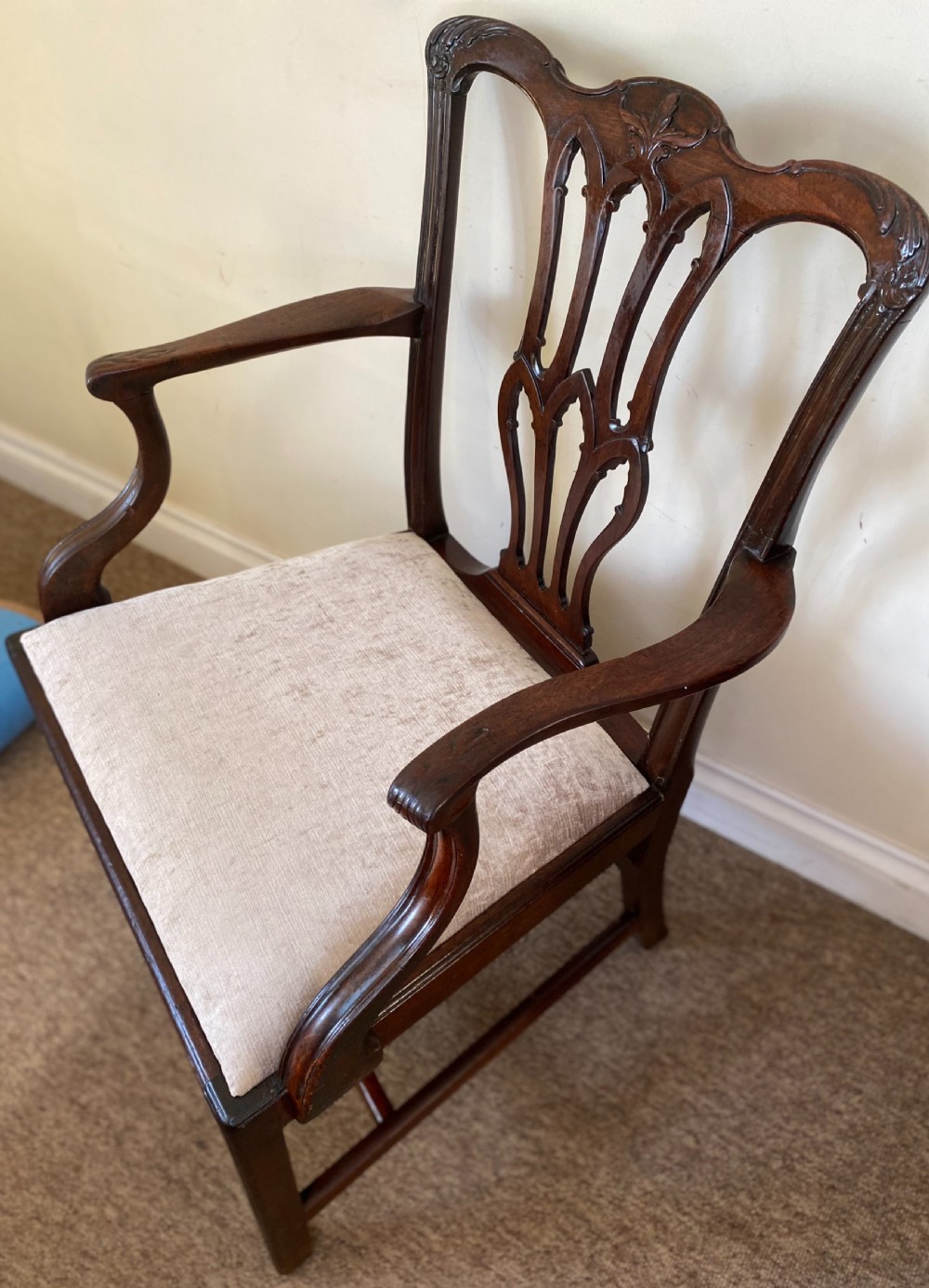 An 18th-century Chippendale mahogany armchair with a pierced carved back splat, swept arms, and a beige upholstered drop-in seat pad. View III