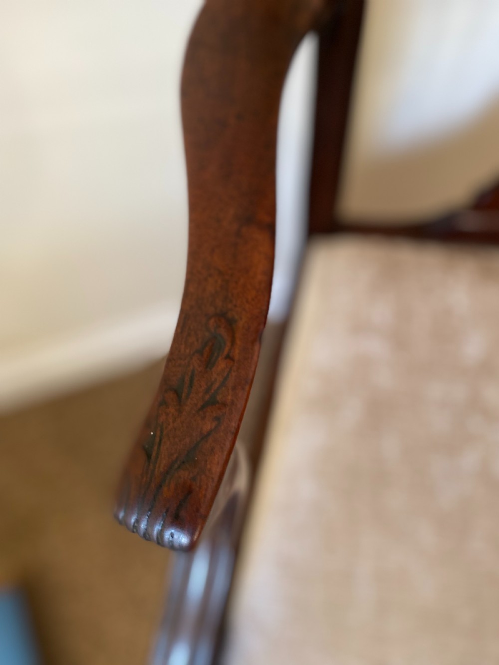 An 18th-century Chippendale mahogany armchair with a pierced carved back splat, swept arms, and a beige upholstered drop-in seat pad. View IV