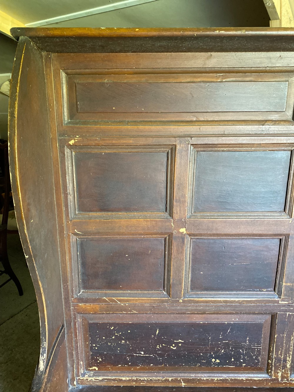A large 19th-century high-back wooden settle featuring a multi-panelled back, winged draught sides, dark distressed finish, and a hinged seat box base. View III