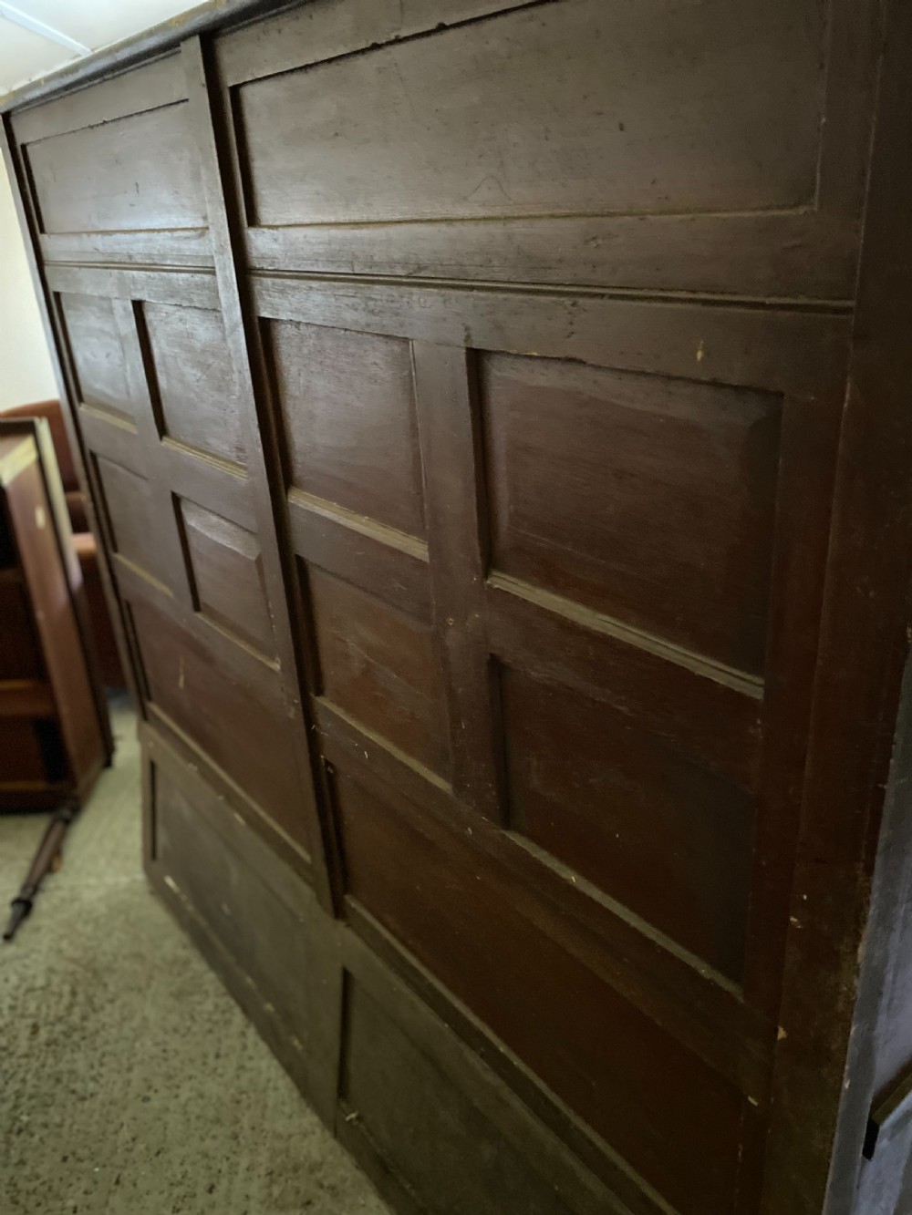 A large 19th-century high-back wooden settle featuring a multi-panelled back, winged draught sides, dark distressed finish, and a hinged seat box base. View IV