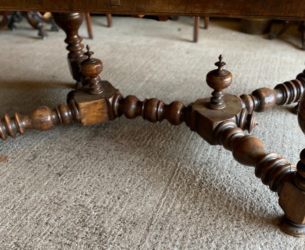 An 18th century Spanish fruitwood refectory dining table featuring a geometric parquet tabletop, draw-leaf extension panels, turned baluster legs, and a carved central stretcher. View VIII